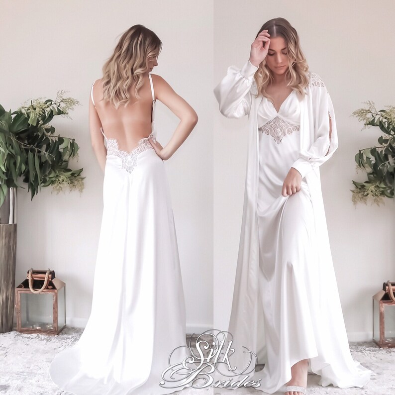 May include: A white satin slip dress with a lace trim and a matching robe. The dress has a low back and the robe has long sleeves and a tie at the waist.