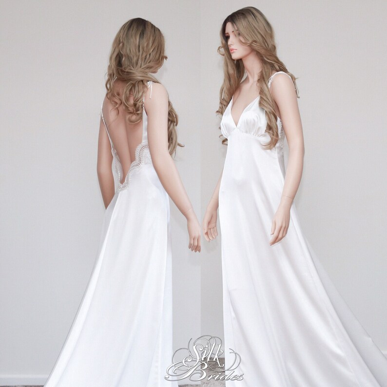May include: A white silk slip dress with a lace trim on the back. The dress has a V-neckline and spaghetti straps.
