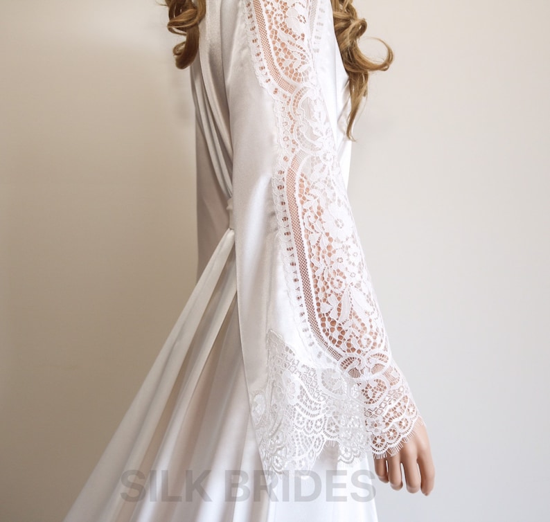 May include: White satin robe with lace trim on the sleeves. The robe has a tie belt and is made of soft, luxurious fabric. The text "SILK BRIDES" is visible at the bottom of the image.