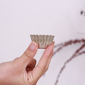 May include: A silver-colored metal cupcake pan with fluted edges.