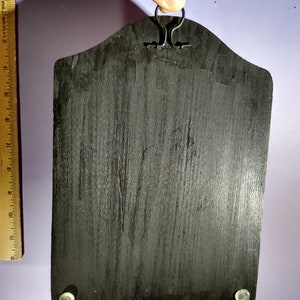 May include: Black wooden key holder with a metal hook at the top and three metal hooks at the bottom. The key holder has a distressed finish.