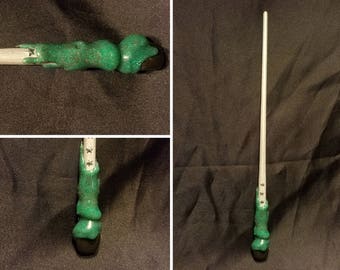 May include: A green and white wand with a black tip and glitter accents. The wand has a star design on the shaft.