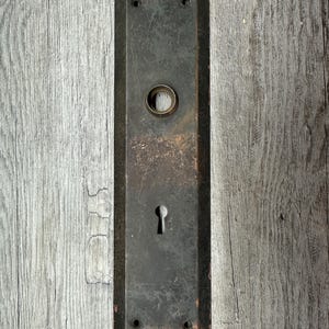 May include: A white ceramic mug with a black handle and the text "But First, Coffee" in a bold, black font. The mug is set against a blurred background, suggesting a cozy setting. The mug appears to be approximately 4 inches tall.