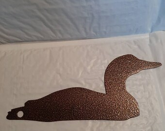 May include: A brown metal loon silhouette with a textured finish. The loon is in a swimming position with its head turned to the side.
