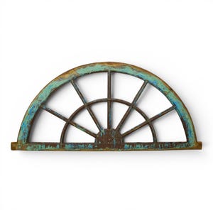 May include: A semi-circular wooden window frame featuring a distressed finish with layers of brown and weathered teal paint. The structure consists of a curved outer arch, a straight base, and six radiating spokes that divide the interior space.