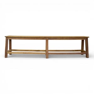 May include: A long, rectangular wooden bench featuring a natural brown finish with visible wood grain. The bench is supported by four straight legs connected by horizontal support bars near the base, creating a simple, open, and sturdy structure.