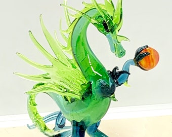 Large green dragon holding a fireball