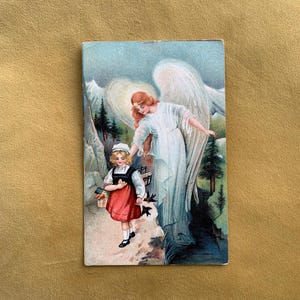 Postal vintage pintada con ilustración de niña ángel de la guarda de los años 20