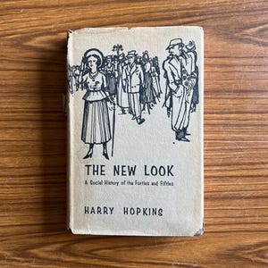 以下が含まれることがあります： ハリー・ホプキンス著のヴィンテージ本「THE NEW LOOK」。表紙には、1940年代と1950年代の服装をした人々の白黒イラストが描かれています。本は使い古された、古びた外観をしており、アンティークであることを示唆しています。