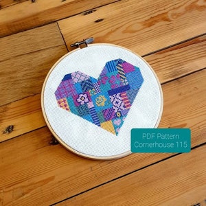 May include: A cross-stitch pattern of a colorful patchwork heart on a white background. The pattern is titled "Cornerhouse 1115" and is available as a PDF download.