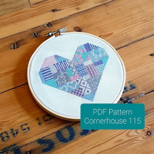 May include: A cross-stitch pattern of a colorful patchwork heart in a wooden embroidery hoop. The pattern is titled "Cornerhouse 115" and is available as a PDF download.