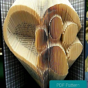 Schema e tutorial per piegare il libro "Zampa nel Cuore" per principianti. Idee regalo fai da te per amanti di cani e gatti. Arte del libro piegato con animali domestici, con guida passo passo.