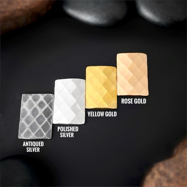 May include: Four metal samples in a rectangular shape, showing different finishes: antiqued silver, polished silver, yellow gold, and rose gold. Each sample has a diamond-shaped pattern.