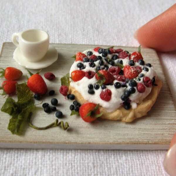 Meringue topped with cream and summer berries on a board