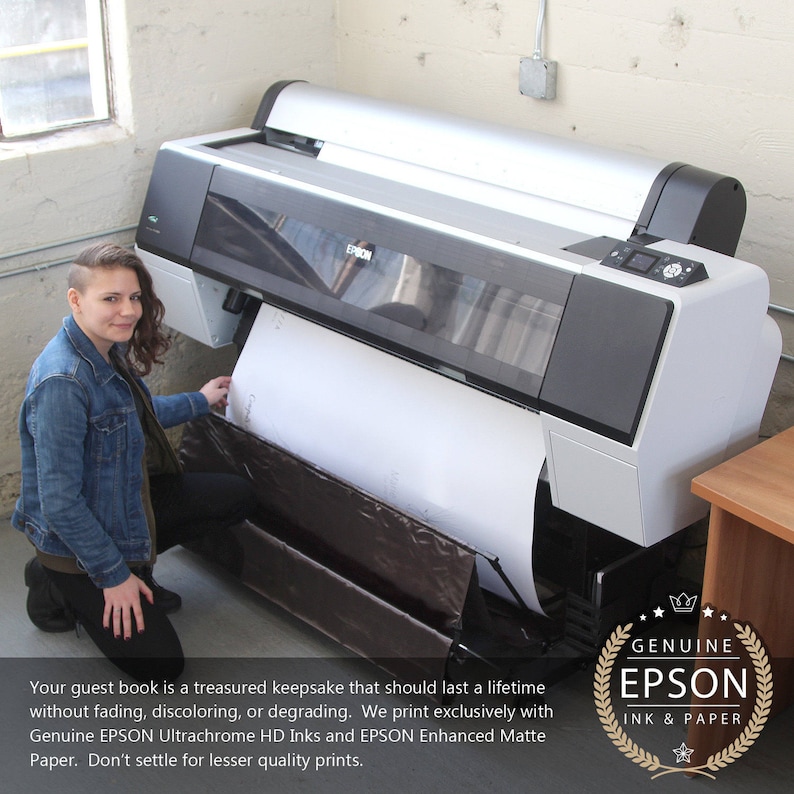 May include: A woman stands next to a large Epson printer, holding a white sheet of paper. The printer is silver and black with the Epson logo on the front. The text on the image reads "Your guest book is a treasured keepsake that should last a lifetime without fading, discoloring, or degrading. We print exclusively with Genuine EPSON Ultrachrome HD Inks and EPSON Enhanced Matte Paper. Don't settle for lesser quality prints."  The image also includes a logo that reads "GENUINE EPSON INK & PAPER".