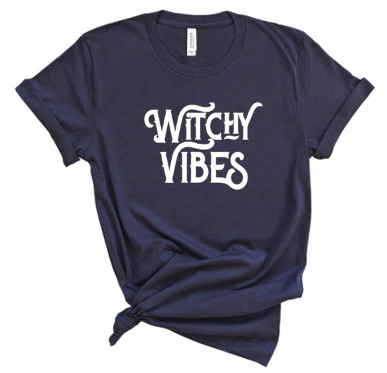 K&ouml;nnte beinhalten: Ein marineblaues T-Shirt mit dem Text "Witchy Vibes" in wei&szlig;en Buchstaben.