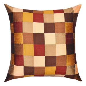 May include: A square patterned throw pillow with a patchwork design in shades of brown, beige, gold, and burgundy.