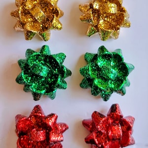 May include: Six sparkly, decorative bows in gold, green, and red. The bows are made of a glittery material and are perfect for adding a festive touch to any project.
