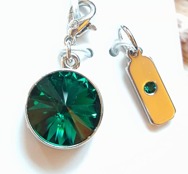 Pode incluir: Dois pingentes de prata. Um pingente apresenta um grande cristal verde redondo. O outro pingente &eacute; uma pequena etiqueta retangular com um cristal verde menor.