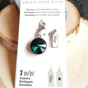 Pode incluir: Dois pingentes prateados com um cristal verde e uma etiqueta prateada gravada com a palavra "Maio". Os pingentes est&atilde;o em um cart&atilde;o branco com o texto "Create Your Style" e "2 pc/pz Charms Breloques Amuletos".