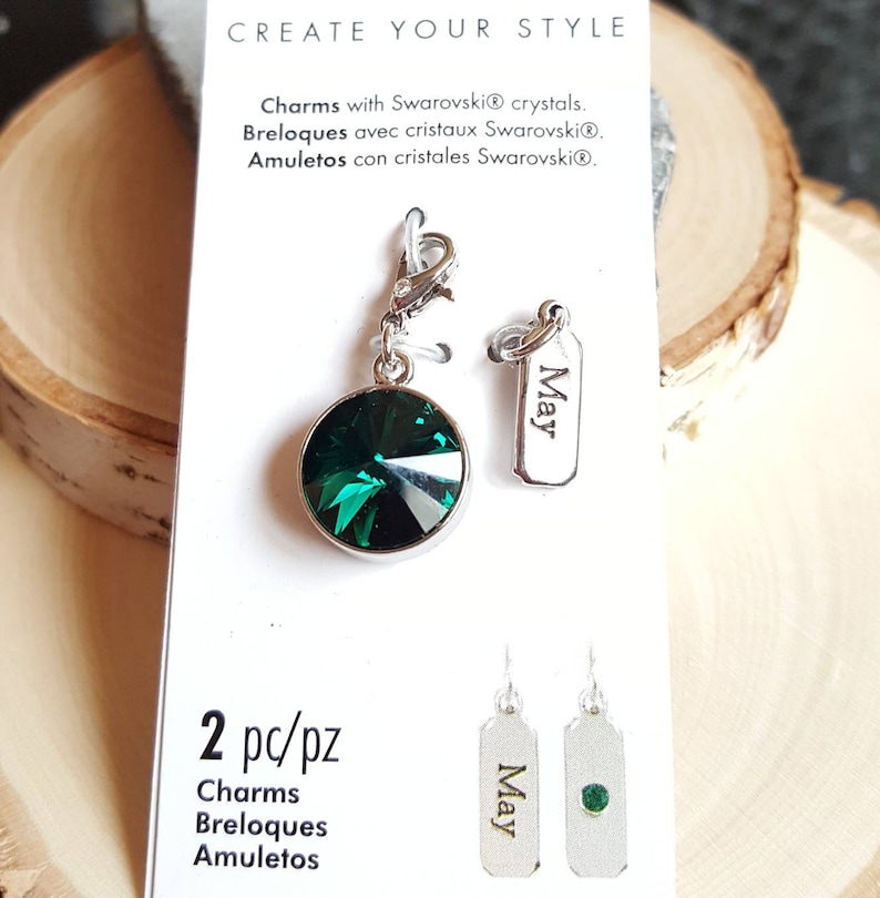 Pode incluir: Dois pingentes prateados com um cristal verde e uma etiqueta prateada gravada com a palavra "Maio". Os pingentes est&atilde;o em um cart&atilde;o branco com o texto "Create Your Style" e "2 pc/pz Charms Breloques Amuletos".