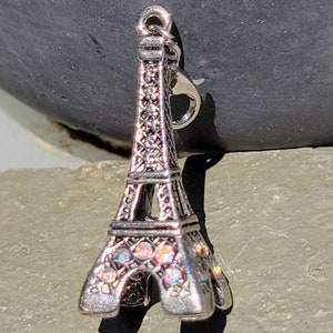 Puede incluir: Encanto de plata en forma de Torre Eiffel con diamantes de imitación iridiscentes. El encanto tiene un cierre de langosta.