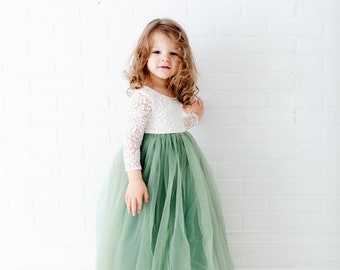 Può includere: Un abito lungo fino ai piedi con corpetto bianco in pizzo a maniche lunghe, scollo rotondo e un'ampia gonna in tulle a strati color verde salvia. Il capo combina un delicato motivo floreale in pizzo sul top con una gonna voluminosa e trasparente.