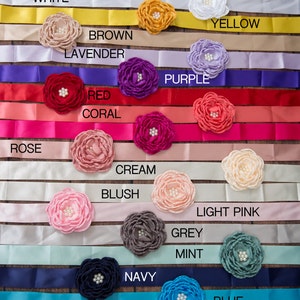 May include: A set of 14 satin ribbon sashes with matching fabric flowers in various colours, including white, brown, lavender, purple, red, coral, rose, cream, blush, light pink, grey, mint, navy, and blue.
