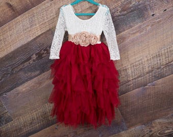 Puede incluir: Un vestido de tul rojo con un corpiño de encaje blanco y un adorno floral en la cintura.