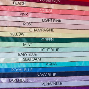 May include: A collection of satin ribbons arranged in horizontal rows, each labeled with its color: black, chocolate, red, burgundy, peach, coral, pink, light pink, rose, champagne, yellow, green, mint, light blue, baby blue, seafoam, aqua, royal blue, navy blue, lavender, periwinkle, purple, ivory, white, and gray.