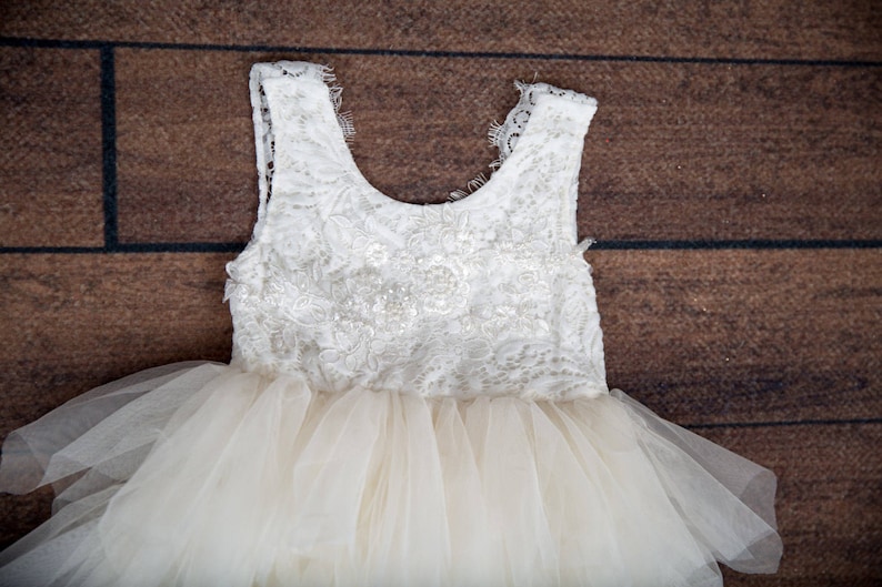 May include: A white tulle dress with a lace bodice. The dress has a full skirt and is perfect for a special occasion.
