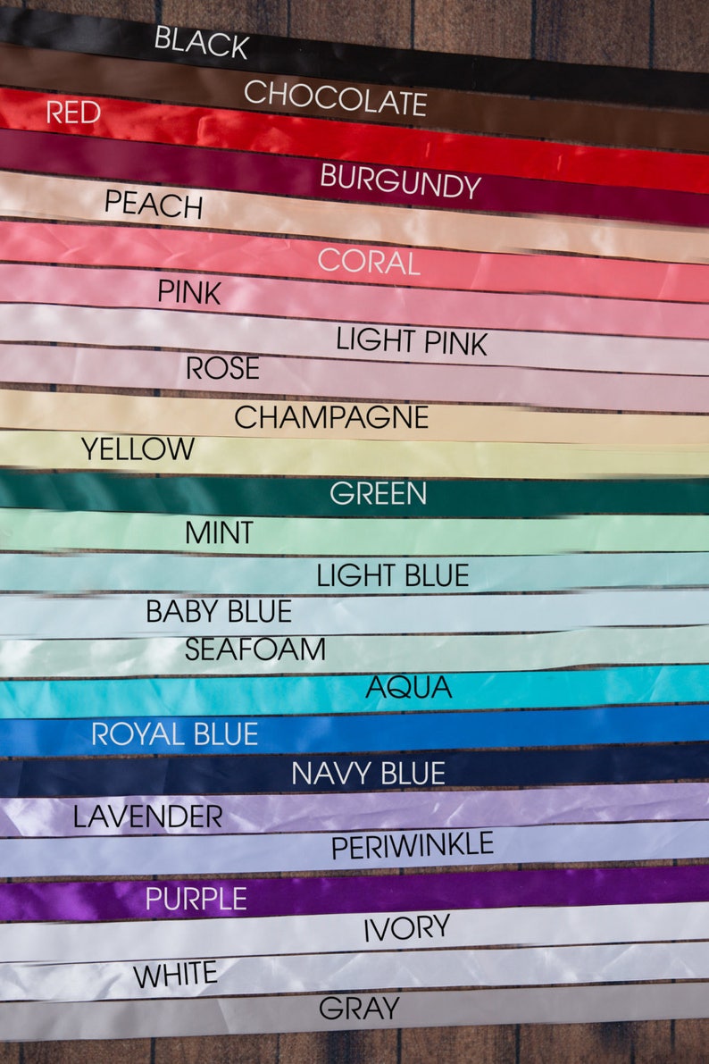 May include: A collection of 18 satin ribbon samples in various colours, including black, red, chocolate, burgundy, peach, coral, pink, light pink, rose, champagne, yellow, green, mint, light blue, baby blue, seafoam, aqua, royal blue, navy blue, lavender, periwinkle, purple, ivory, white, and grey.