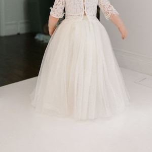 May include: A white tulle skirt with a lace top, perfect for a flower girl or special occasion.