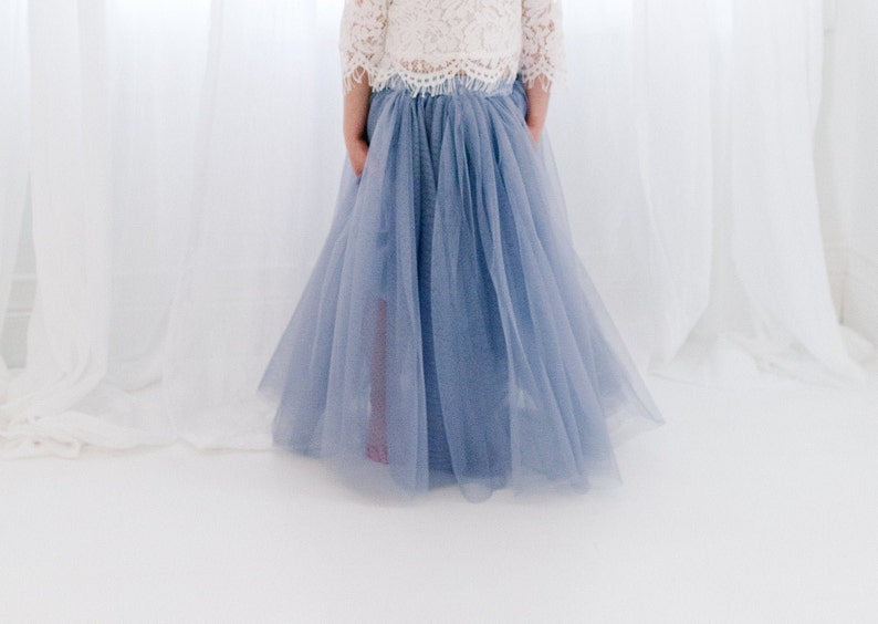 May include: A light blue tulle skirt with a white lace top. The skirt is full and flowing, and the top is delicate and feminine.