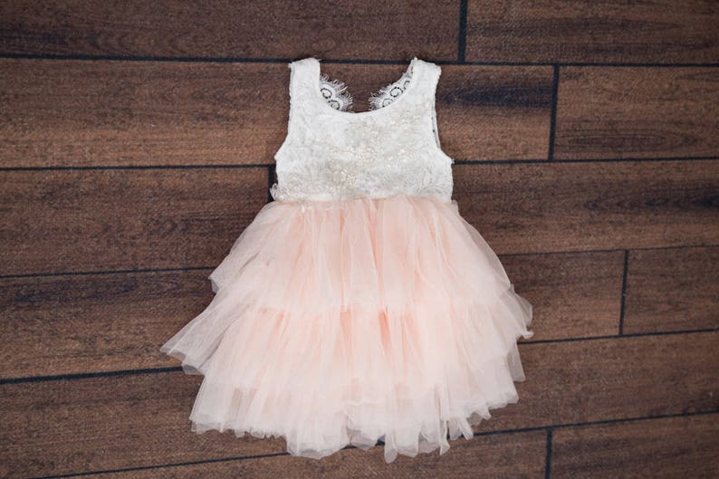 May include: A white and pink tulle dress with a lace bodice. The dress has a layered skirt and is perfect for a special occasion.