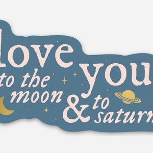May include: A blue sticker with the text "love you to the moon & to saturn" in pink lettering. The sticker features a crescent moon, a planet with rings, and stars.
