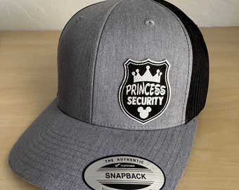 May include: Gray and black mesh trucker hat with a white embroidered patch that says "Princess Security" with a crown and a Mickey Mouse head.