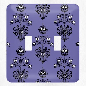 May include: Purple light switch cover with a black and white repeating pattern of a haunted house with ghosts and owls.