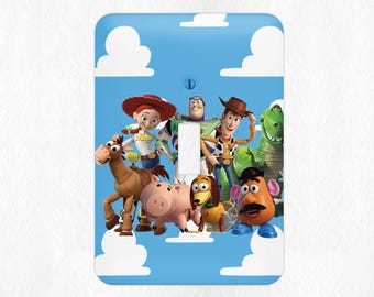May include: A light switch cover featuring characters from the Toy Story movie franchise. The cover is blue with white clouds and features Woody, Buzz Lightyear, Jessie, Bullseye, Rex, Slinky Dog, and Mr. Potato Head.