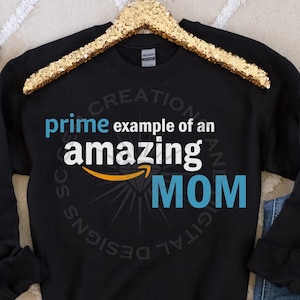 May include: Black sweatshirt with a white graphic design that says "prime example of an amazing MOM" with the Amazon logo in the middle of the graphic.