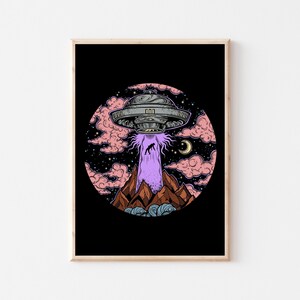 Puede incluir: Ilustraci&oacute;n enmarcada que representa un OVNI abduciendo a una figura de una cordillera. La obra tiene un fondo negro con un dise&ntilde;o circular de nubes rosas, estrellas y una luna creciente. El OVNI es plateado y el rayo es morado.