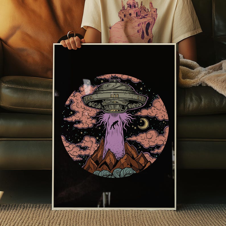 Puede incluir: Una impresi&oacute;n art&iacute;stica enmarcada con una ilustraci&oacute;n retro de un OVNI que emite una figura desde una monta&ntilde;a. La obra de arte est&aacute; ambientada sobre un fondo negro con nubes rosas, estrellas y una luna creciente. El OVNI es gris met&aacute;lico.