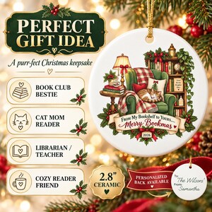 Può includere: Un ornamento natalizio rotondo in ceramica bianca da 7,1 cm con la grafica di un gatto che dorme su una poltrona verde accanto a una libreria. Il testo recita From My Bookshelf to Yours Merry Bookmas 2026. Un'etichetta circolare bianca più piccola mostra To The Wilsons From Samantha.