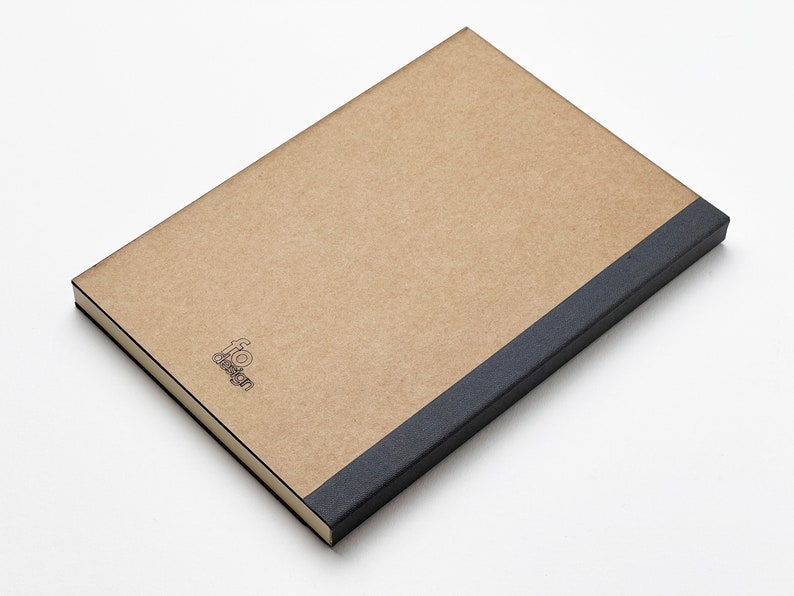 a brown notebook with a black cover on a white surface