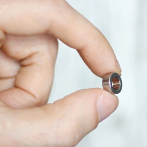 以下が含まれることがあります： 滑らかで磨かれた仕上げの小さな銀色の金属リング