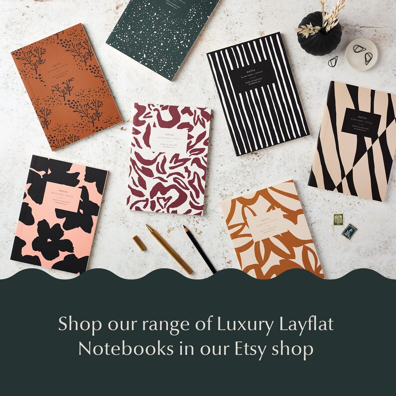 May include: Assortment of colorful notebooks with various abstract patterns, including floral, geometric, and animal print designs. The notebooks are arranged on a white surface with a gold pen and pencil. Shop our range of Luxury Layflat Notebooks in our Etsy shop.