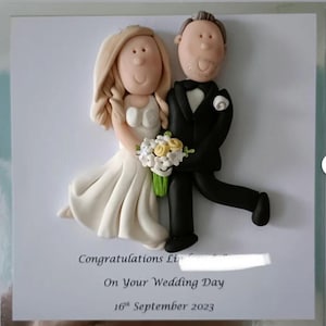 May include: A wedding card featuring a bride and groom figurine. The bride wears a white dress and holds a bouquet. The groom is in a black tuxedo. The card reads "Congratulations" and "On Your Wedding Day, 16th September 2023."