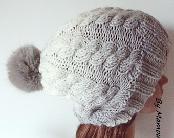 Bonnet femme à torsades tricoté main dans un joli dégradé de blanc au gris et son pompon fausse fourrure gris clair