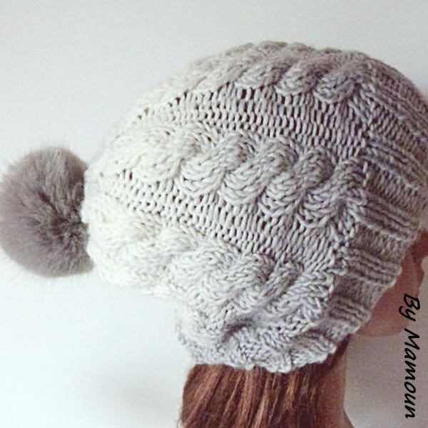 Bonnet femme à torsades tricoté main dans un joli dégradé de blanc au gris et son pompon fausse fourrure gris clair