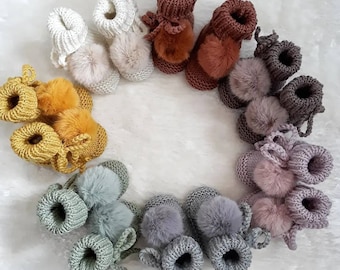 Hand-knitted baby slippers in 100% merino yarn and their faux fur pompoms, size 3 months